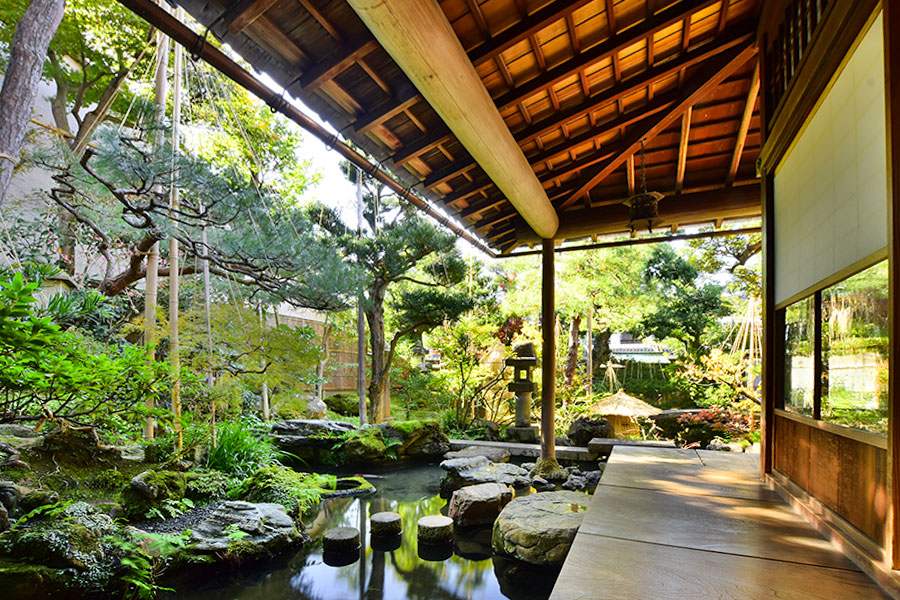 Ein kleiner Garten mit Teich umgibt ein traditionelles japanisches Haus