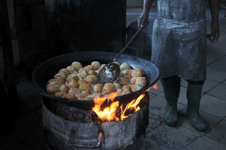 In einem Kessel über offenem Feuer werden kenianische Mandazi frittiert