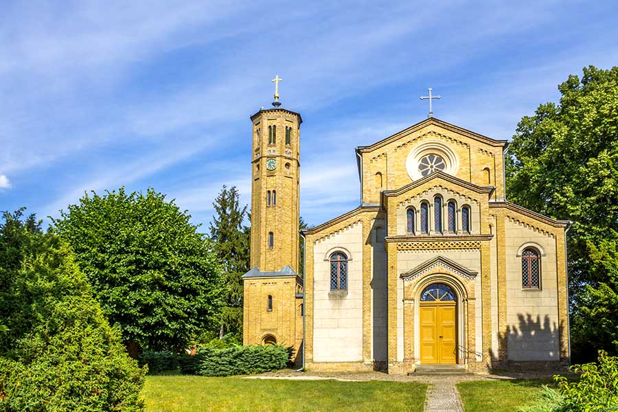 Gelbe Baksteinkirche mit freistehendem Glockenturm