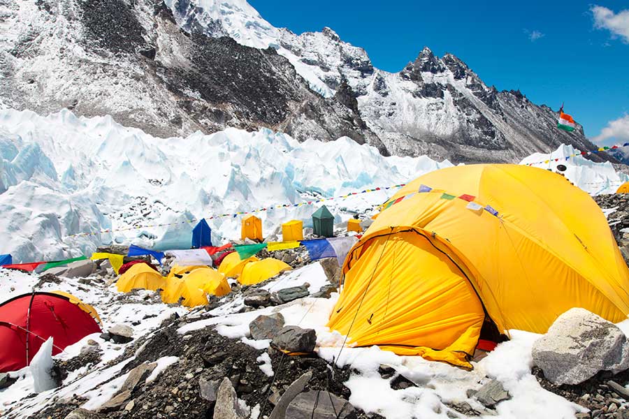 Bunte Zelte vor Gletscher und Hochgebirgskulisse